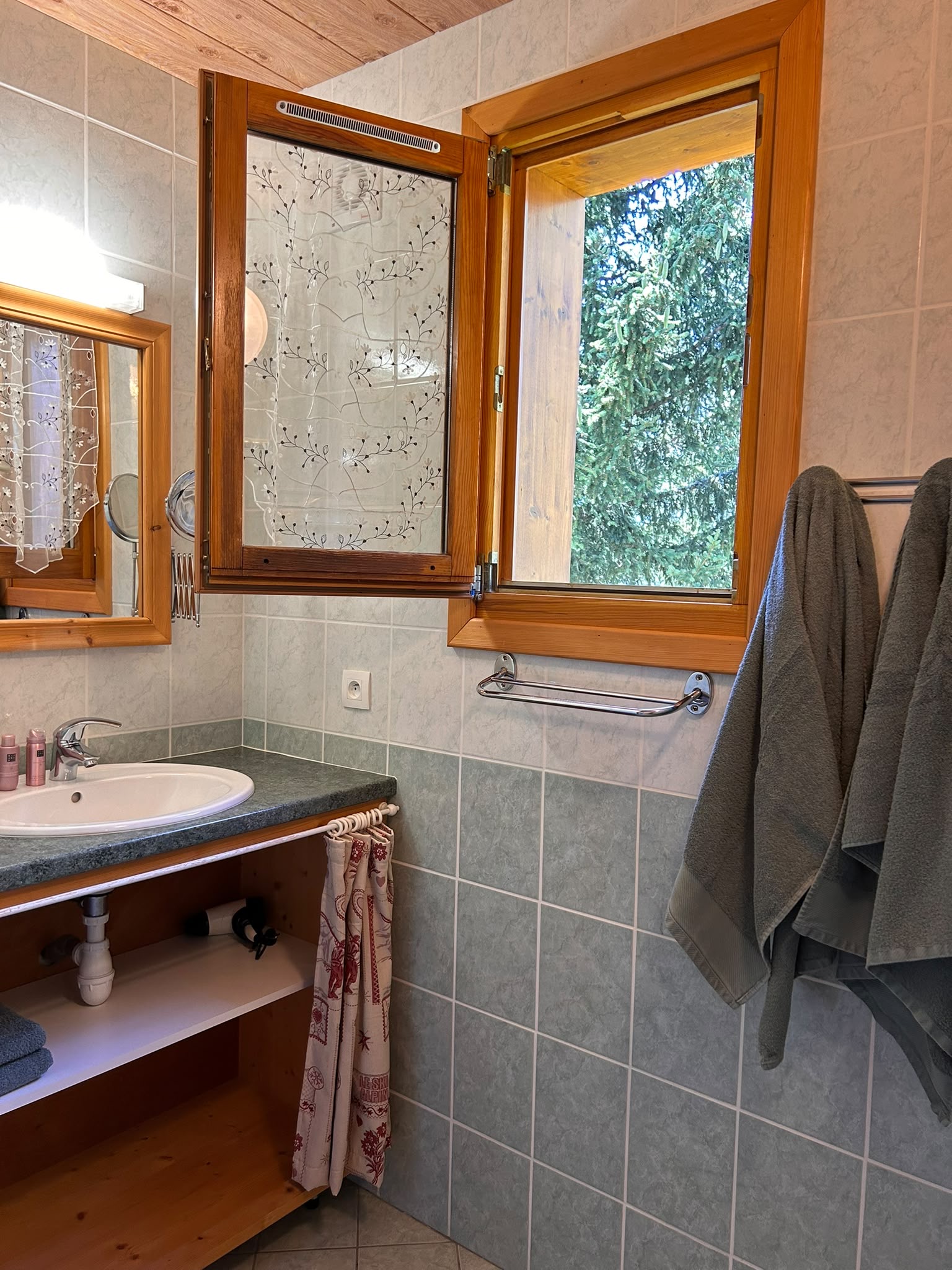Salle de bain avec meuble vasque et fenêtre d’angle